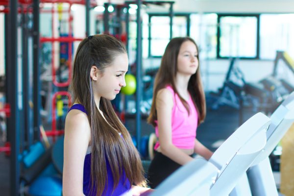Teen girls training. Two beautiful teenage in the gym