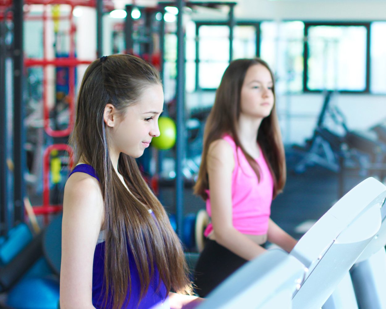 Teen girls training. Two beautiful teenage in the gym