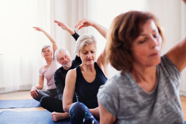 Four older people taking part in a yoga class