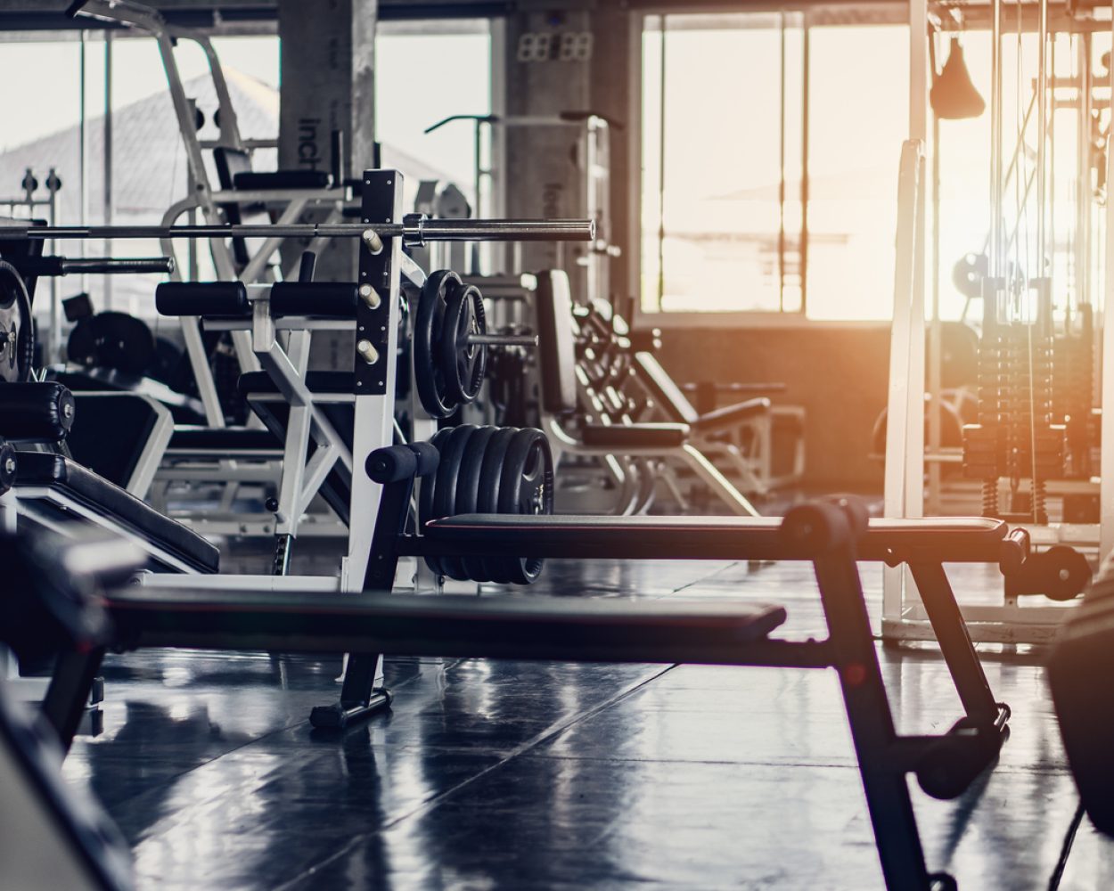 interior background of room in gym or fitness center fully equip of bodybuilding equipments and machines