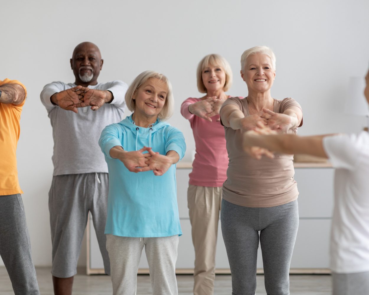 Sporty elderly people having fitness class, training with instructor