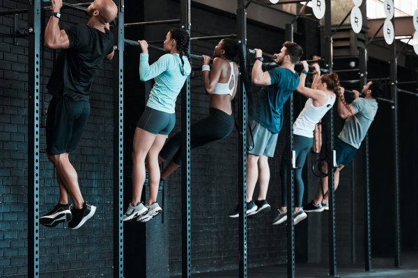 Shot of a group of people completing pull ups together