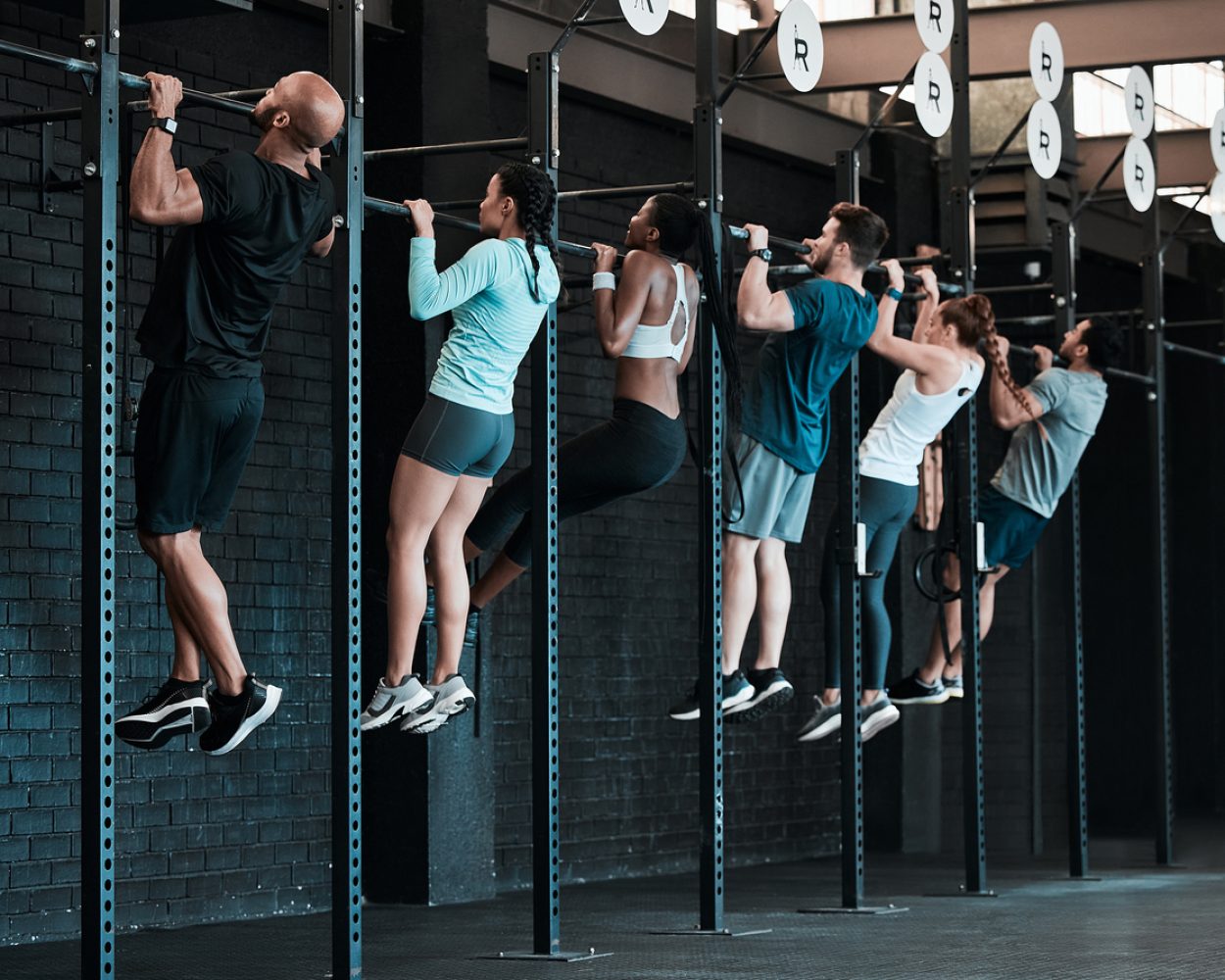 Shot of a group of people completing pull ups together