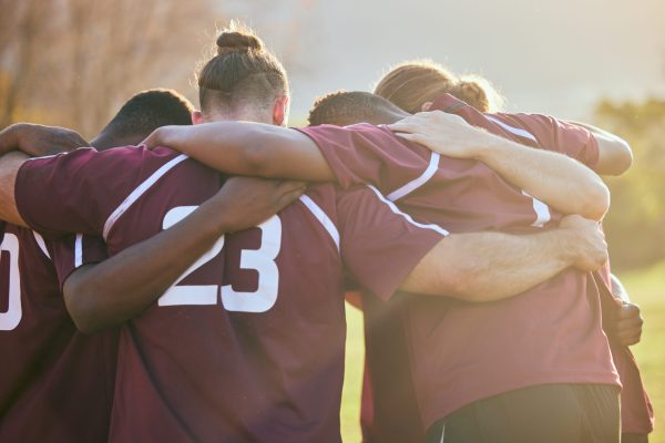 Teammates huddle together to support each other.