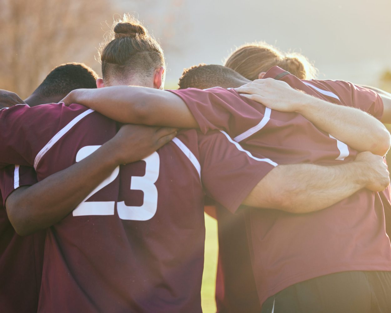 Teammates huddle together to support each other.