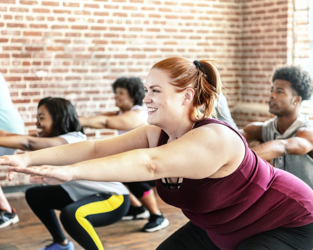 People doing squats in fitness class