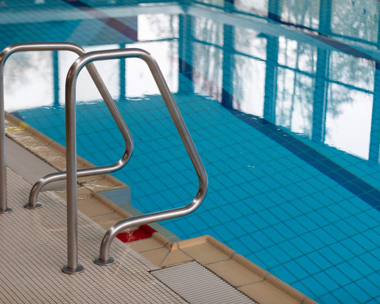 Modern Indoor Pool with Sleek Railing and Clear Blue Water