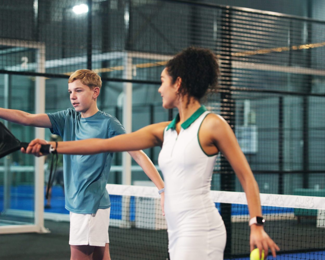 Coach, child and woman with padel racket on court for learning sports, training and exercise. Personal trainer, fitness and person with children at practice for playing game, tournament and match