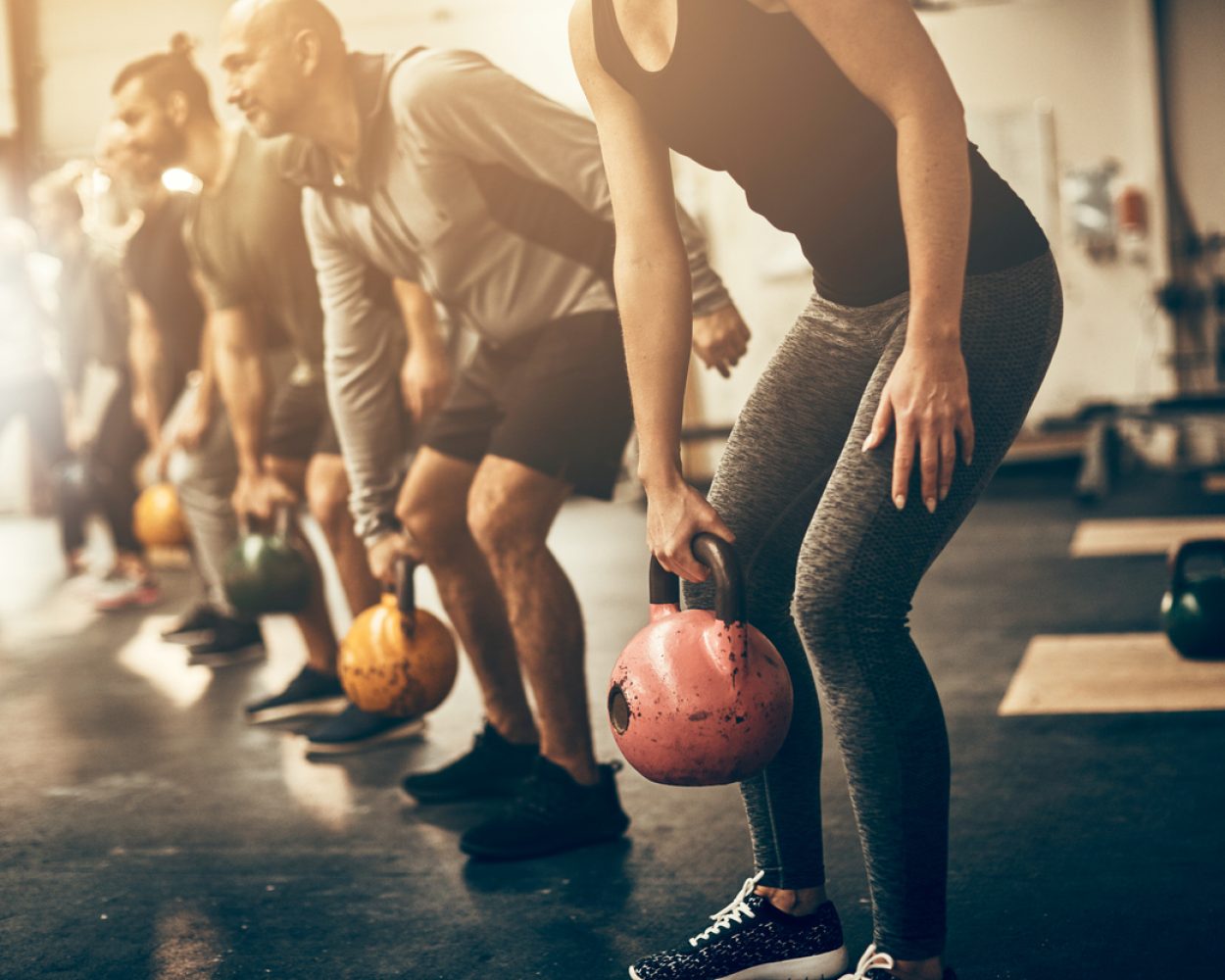 Fit people lifting dumbbells together during a workout session